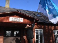 Metsküla kooli vilistlane Märten Hermik vabastab tuulest keerdu kammitsetud oma kooli lipu uuesti vabalt lehvima. Foto: Urmas Saard