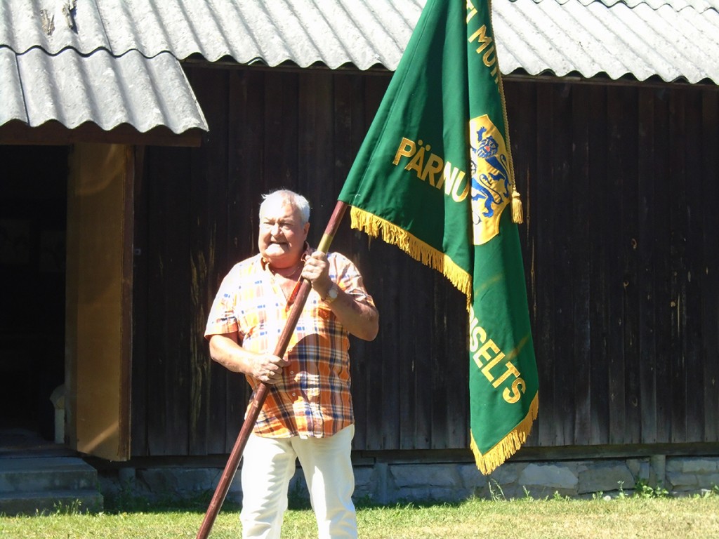 Mati Rosenstein Pärnu-Jaagupi muinsuskaitse seltsi lipuga muuseumi õuel