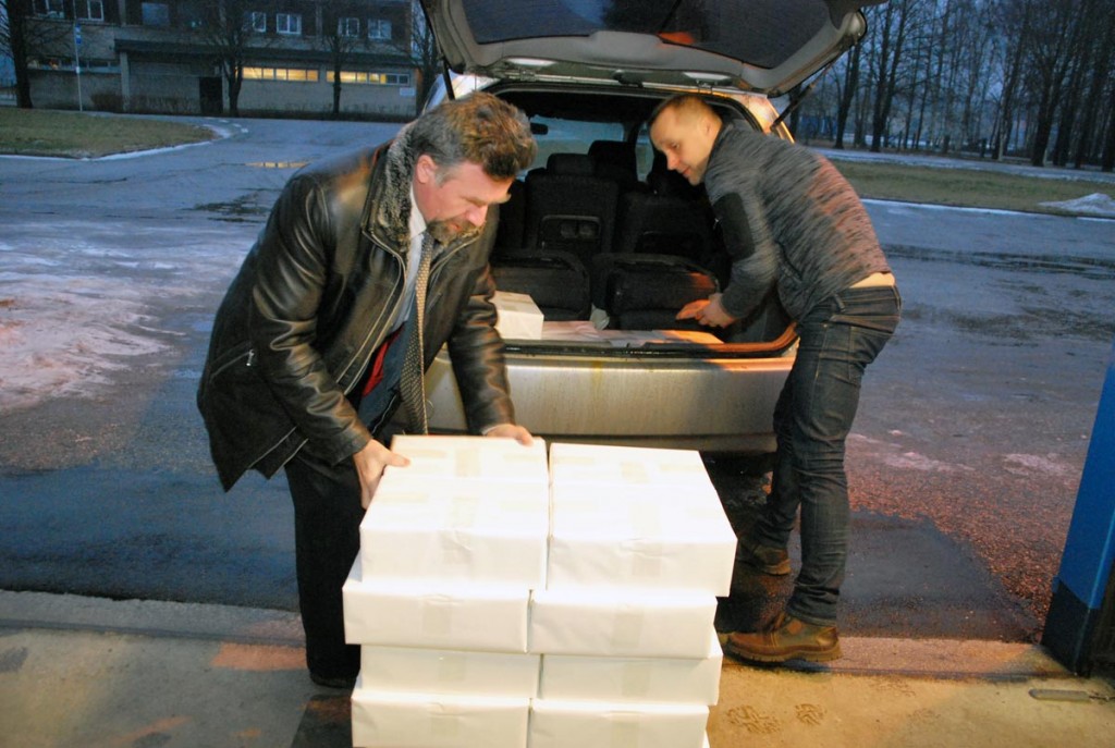 Mati Sutt tõstab koos Hansprindi töötajaga raamatute pakid autole Foto Urmas Saard