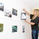 Sindi sotsiaaltöökeskuse juhataja Renna Järve paigutab Mikk Rätsepa fotosid seinale. Foto Urmas Saard